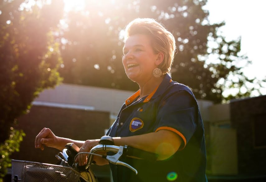 Medewerker van Groene Kruis Thuiszorg op de fiets