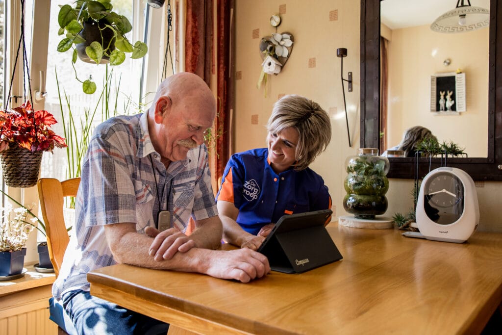 Zorgmedewerkster geeft uitleg over de Compaan aan de cliënt