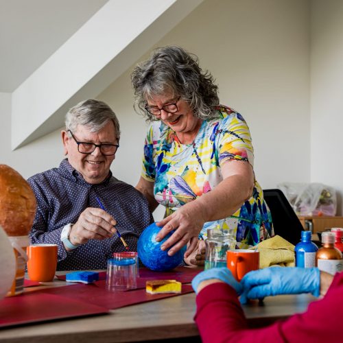 Zorgmedewerker en cliënt tijdens een knutselactiviteit